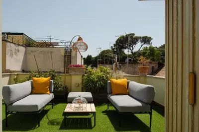a patio with two chairs and a table at Rooftop Colosseo - Roma d'Amore in Rome