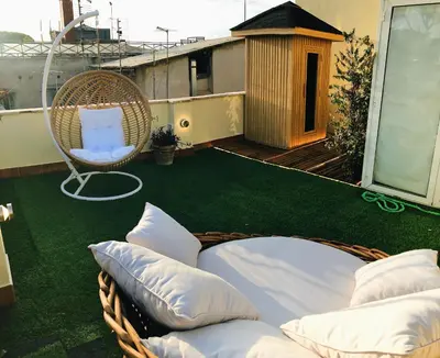 a balcony with a wicker chair and pillows at Rooftop Colosseo - Roma d'Amore in Rome