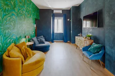 a living room with a yellow couch and blue walls at Rooftop Colosseo - Roma d'Amore in Rome