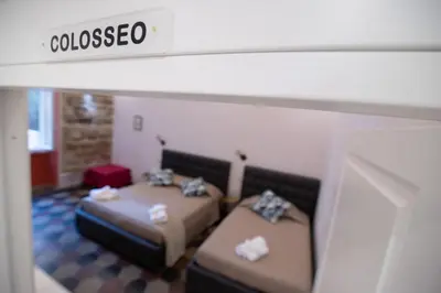 a room with two beds and a sign that reads glucoseo at Museum Inn - Una finestra sui Musei Vaticani in Rome