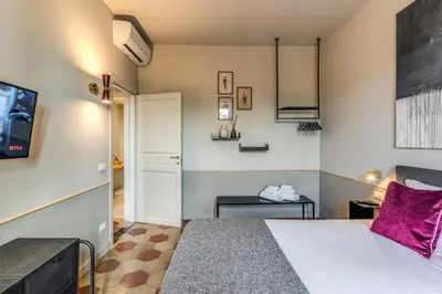 a bedroom with a large bed with a purple pillow at CORNER211 in Rome