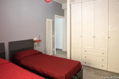 a bedroom with a red bed and a white cabinet at Nido di Pina in Rome