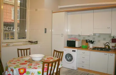 a kitchen with a table and a washing machine at Montebello - Julia Apartment in Rome
