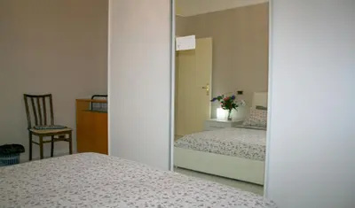 a mirror in a bedroom with two beds and a chair at Montebello - Julia Apartment in Rome
