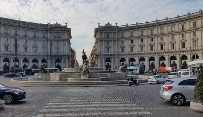 a large building with a fountain in the middle of a street at Montebello - Julia Apartment in Rome