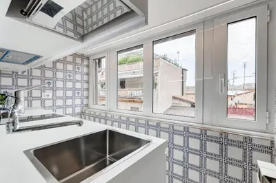 a kitchen with a sink and two windows at Frattina High-end apt in Rome