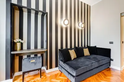 a living room with a couch and a striped wall at Frattina High-end apt in Rome