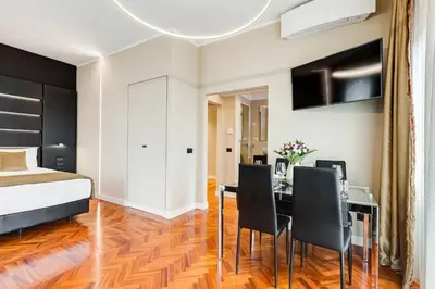 a bedroom with a bed and a dining room with a table and chairs at Frattina High-end apt in Rome