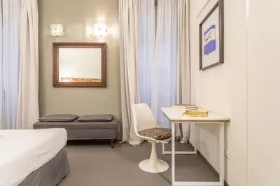a room with a bed and a table and a chair at Spanish Steps DeLuxe Apartment in Rome