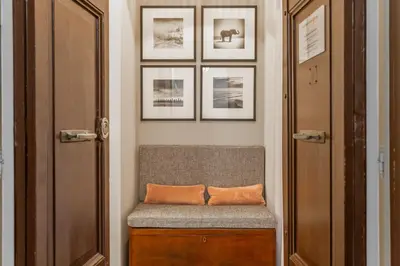 a bench with an orange pillow sitting in a hallway at Spanish Steps DeLuxe Apartment in Rome