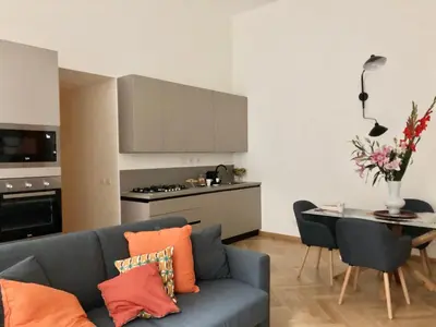 a living room with a blue couch and a kitchen at Opera Luxury Rosmini in Rome