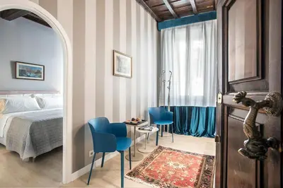 a bedroom with a bed and a table and chairs at La Finestra su Fontana di Trevi - Charming View in Rome