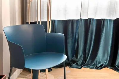a blue chair sitting in front of a window at La Finestra su Fontana di Trevi - Charming View in Rome