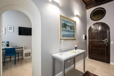 a room with a table and a desk and a door at La Finestra su Fontana di Trevi - Charming View in Rome