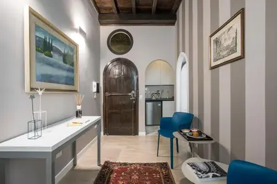 a living room with a table and blue chairs at La Finestra su Fontana di Trevi - Charming View in Rome