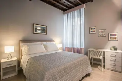 a bedroom with a bed and a desk and a window at La Finestra su Fontana di Trevi - Charming View in Rome