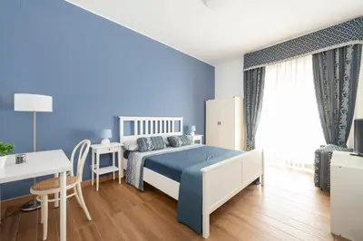 a blue bedroom with a bed and a desk at B&B Il Dogandiere in Rome