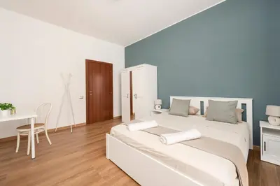 a white bedroom with a bed and a desk at B&B Il Dogandiere in Rome