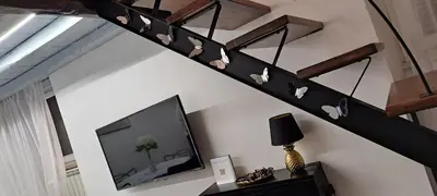 a living room with a staircase with a tv at Clementinam Suite Colosseum in Rome