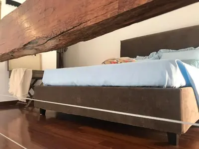 a bed with blue sheets on top of it at Clementinam Suite Colosseum in Rome