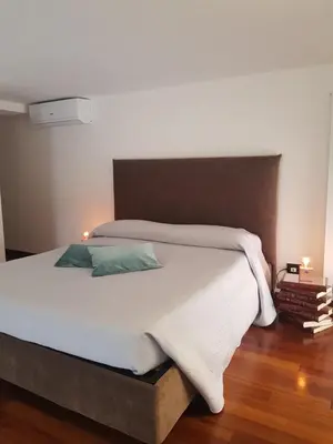 a bedroom with a large white bed with two pillows at Clementinam Suite Colosseum in Rome