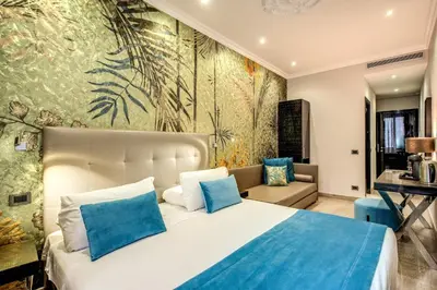a bedroom with a large bed with blue pillows at Relais De La Poste in Rome