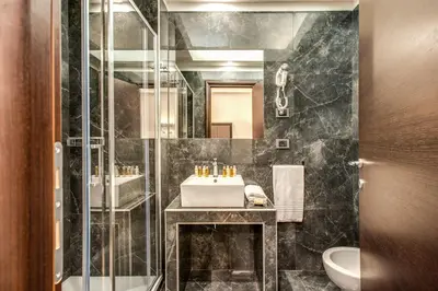 a bathroom with a sink and a shower at Relais De La Poste in Rome
