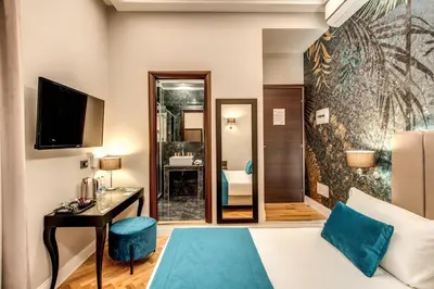 a hotel room with a bed and a desk at Relais De La Poste in Rome