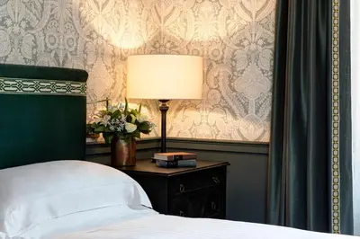 a bedroom with a bed and a table with a lamp at Rocco Forte House Piazza Di Spagna, Rome in Rome