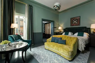 a bedroom with a bed and a couch and a table at Rocco Forte House Piazza Di Spagna, Rome in Rome