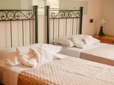 two beds with white sheets sitting next to each other at Charming apartment in San Giovanni 90m from Metro in Rome