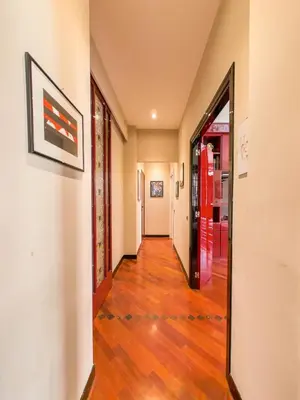 an empty hallway with a hard wood floor and a red door at Charming apartment in San Giovanni 90m from Metro in Rome