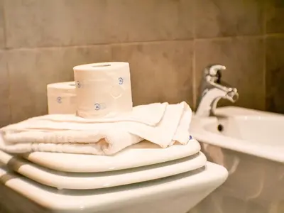 a bathroom with a toilet with towels and a sink at Charming apartment in San Giovanni 90m from Metro in Rome