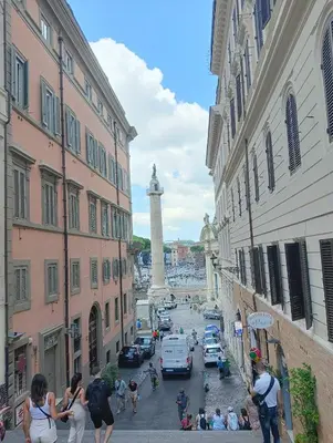 a group of people walking down a street between buildings at Novembre 152 Apartment in Rome