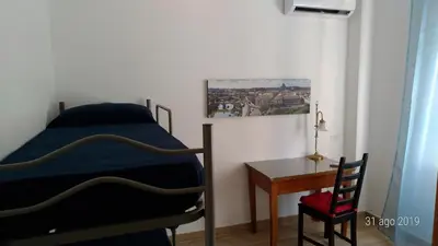 a bedroom with a bed and a desk and a chair at Casa di Rosita in Rome