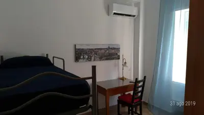a bedroom with a bed and a desk and a chair at Casa di Rosita in Rome