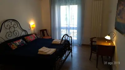 a bedroom with a black bed and a table and a window at Casa di Rosita in Rome