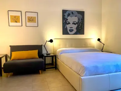 a bedroom with a large bed and a chair at Suite Marilyn - Flaminio - Olimpico - Auditorium in Rome