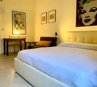 a bedroom with a large white bed and a desk at Suite Marilyn - Flaminio - Olimpico - Auditorium in Rome