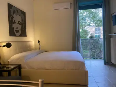 a bedroom with a bed and a door to a balcony at Suite Marilyn - Flaminio - Olimpico - Auditorium in Rome