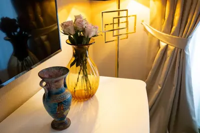 a vase and a vase with flowers on a table at Cathy's Luxury Home in Rome