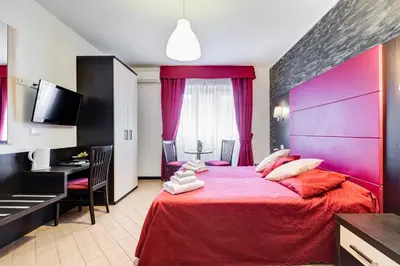 a bedroom with a large red bed with purple sheets at Dreams Of Rome in Rome