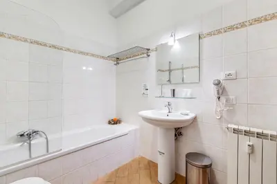 a bedroom with a red bed and a bathroom at Dreams Of Rome in Rome