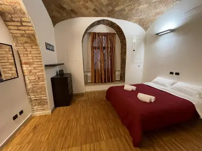 a bedroom with a red bed with two towels on it at Heart of San Lorenzo - La casa particular in Rome