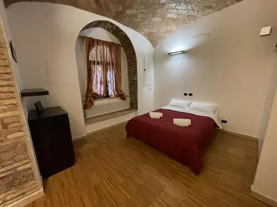 a bedroom with a red bed and a window at Heart of San Lorenzo - La casa particular in Rome