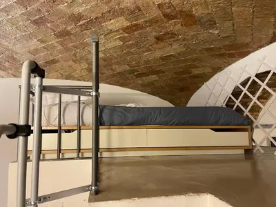 a bunk bed in a room with a brick wall at Heart of San Lorenzo - La casa particular in Rome