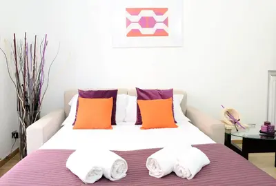 a bedroom with a bed with orange and purple pillows at Fantasie in Trastevere in Rome