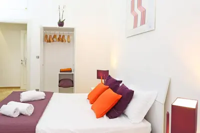 a bedroom with a white bed with orange and purple pillows at Fantasie in Trastevere in Rome