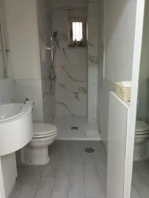 a white bathroom with a toilet and a shower at Fantasie in Trastevere in Rome