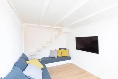 a living room with a blue couch and a tv at Mini appartamento Colosseo in Rome